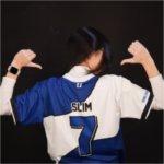 Sydney Lim from the back with her esports jersey on, No. 7 with name Slim, giving two thumbs up